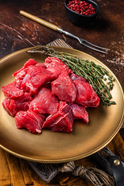 istock Raw diced lamb mutton meat with thyme. Dark background. Top view 1363145435