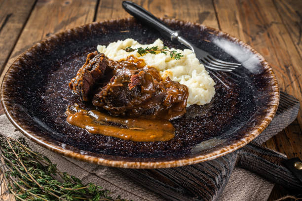 istock Beef cheeks stewed in red wine sauce with mashed potatoes. Wooden background. Top view 1363146465
