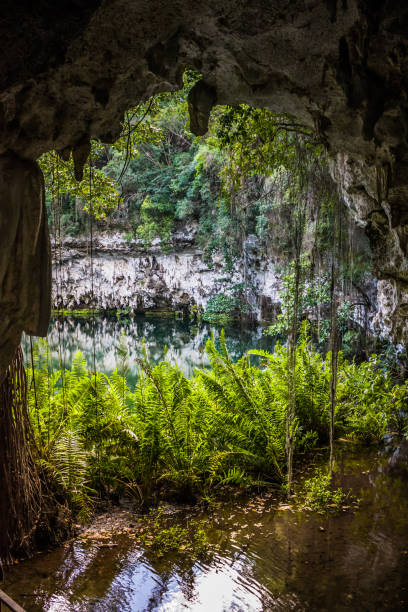 istock Exit from the water cave in the jungle to a small lake surrounded by mountains. Beautiful tropical nature. 1363148769