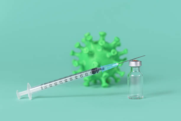 istock Vaccine vial with syringe and corona virus model 1363148938