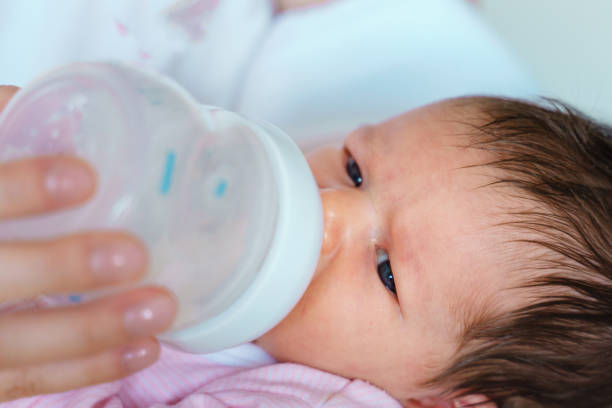 istock one week old baby lying while bottle feeding artificial formula milk close up 1363149722