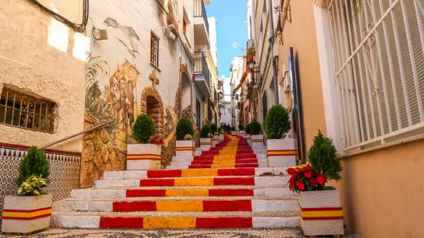 Stairs of a street of Calpe in Alicante painted with the colors of the national flag.