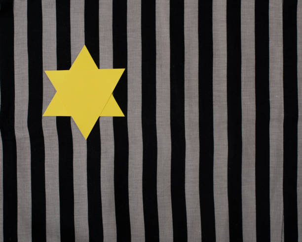 yellow star of david on striped fabric. to remember the victims of the holocaust and genocide. - holocausto imagens e fotografias de stock
