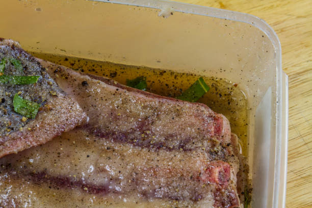istock Pork belly in dry salt cure  becoming bacon with liquid, close up. 1363154849