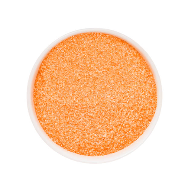 SPA concept. Orange bath sugar in bowl isolated over white background with clipping path SPA concept. Orange bath sugar in bowl isolated over white background with clipping path. Top view exfoliation photos stock pictures, royalty-free photos & images