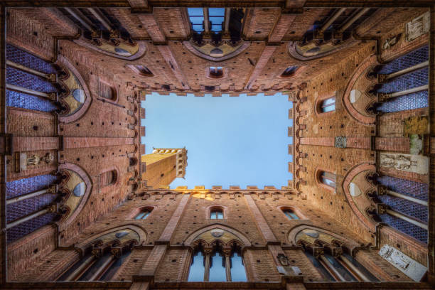 patio icónico del palacio palazzo pubblico (ayuntamiento) en el centro histórico de siena, toscana, italia - torre del mangia fotografías e imágenes de stock