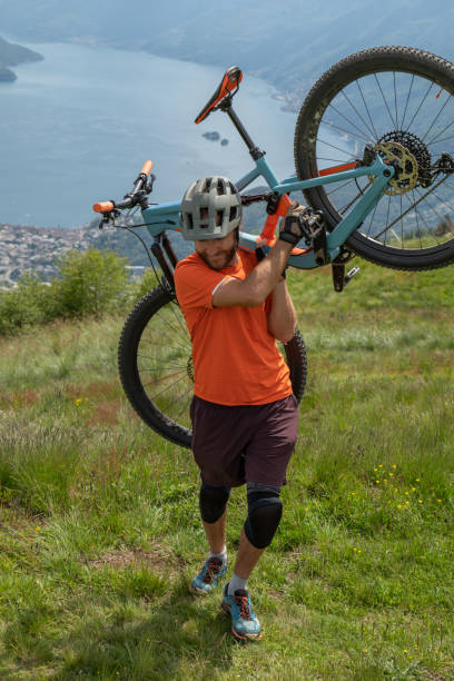 istock Mountain biker climbs up mountain ridge with bicycles 1363156176