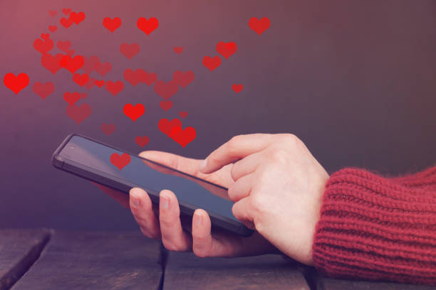 istock woman hands using smartphone with heart icon on dark background. 1363159534
