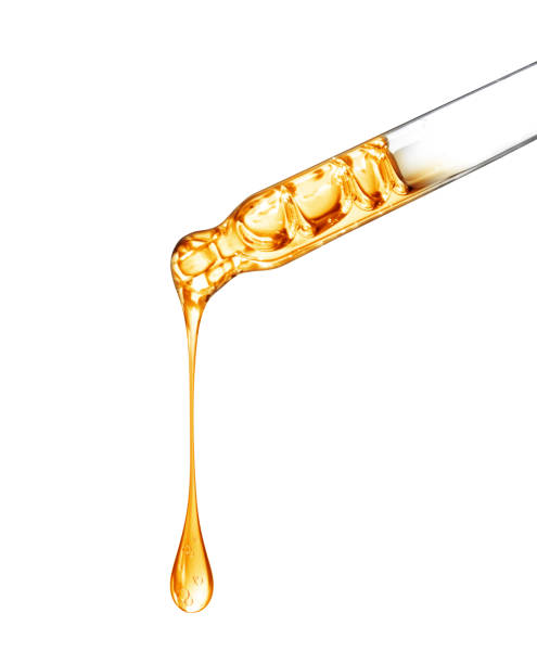 istock Cosmetic pipette with a yellow oily drop close up on white background 1363164729