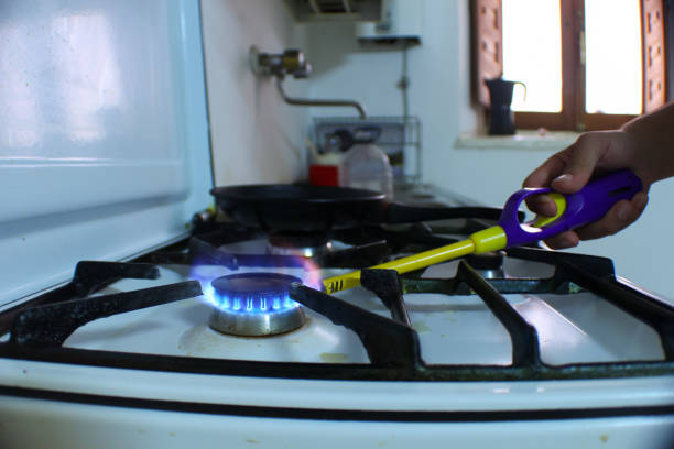 person lighting a fire on a butane stove