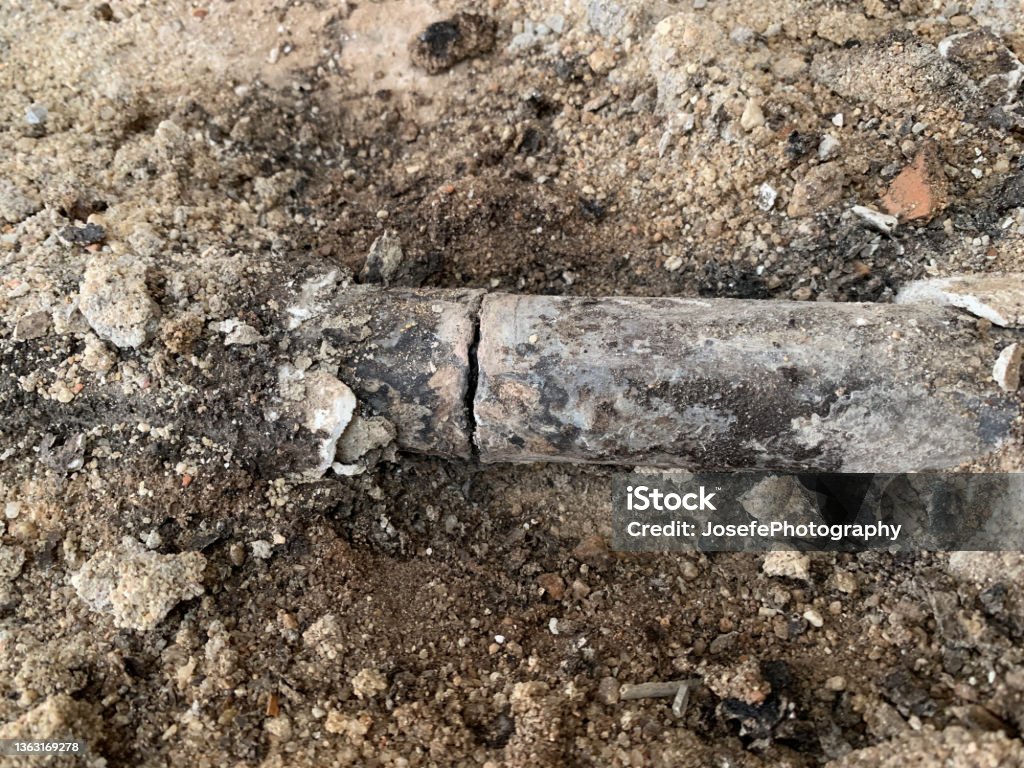 lead pipe Scratched lead pipe, embedded in the ground Lead Stock Photo