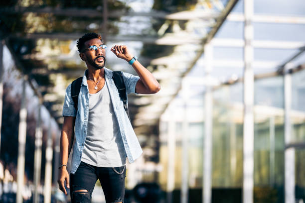 istock Black man with glasses and backpack walking down the street 1363169879