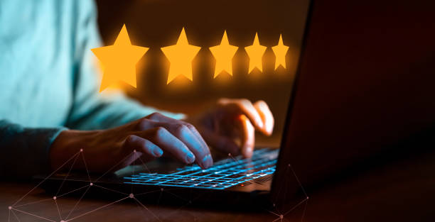 A person gives a five-star rating online using laptop. Female hands are typing on the laptop keyboard, close-up view. The person leaves a five-star review for the service, hotel, restaurant, the impression of buying online. five people stock pictures, royalty-free photos & images