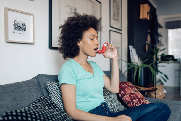 istock Young Afro woman using asthma inhaler at home 1363169905