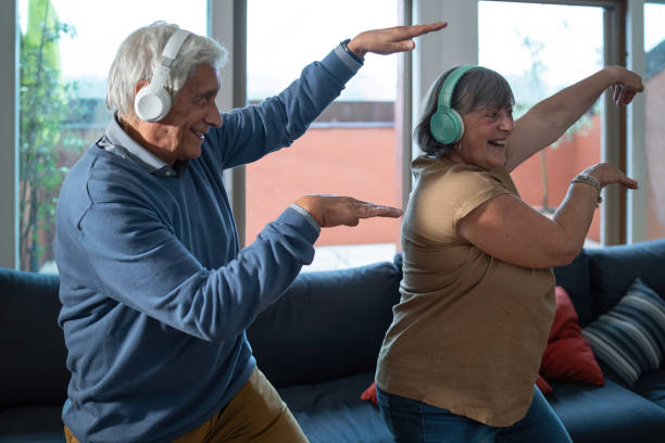 아주 좋은 조부모는 거실에서 집에서 춤을 추며 잘 맞습니다. 집에서 건강한 활동을 하는 노인들. - humor music headphones women 뉴스 사진 이미지