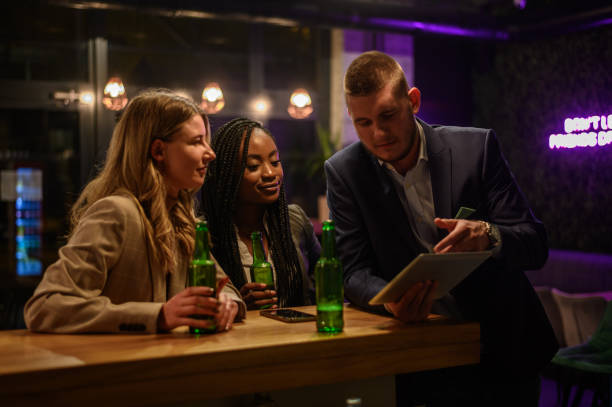 istock Cheerful colleagues drinking beer in the bar together after work 1363172553