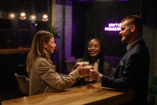istock Cheerful colleagues drinking beer in the bar together after work and using a tablet 1363172558