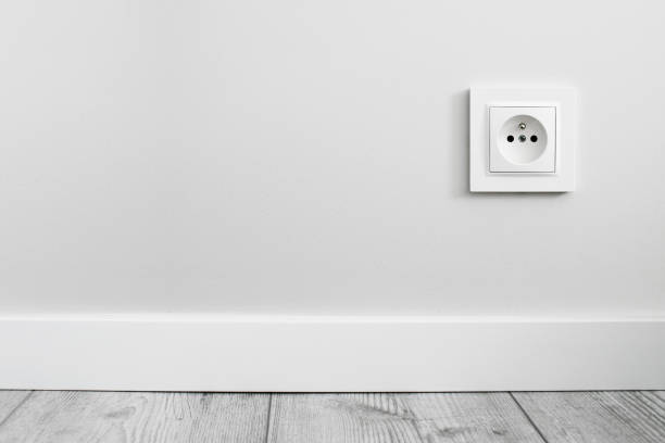 istock New electrical socket isolated on gray wall. Renovated studio apartment power supply background. Gray wooden floor. 1363176257