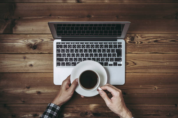 istock Overhead view of laptop and human hands 1363176402