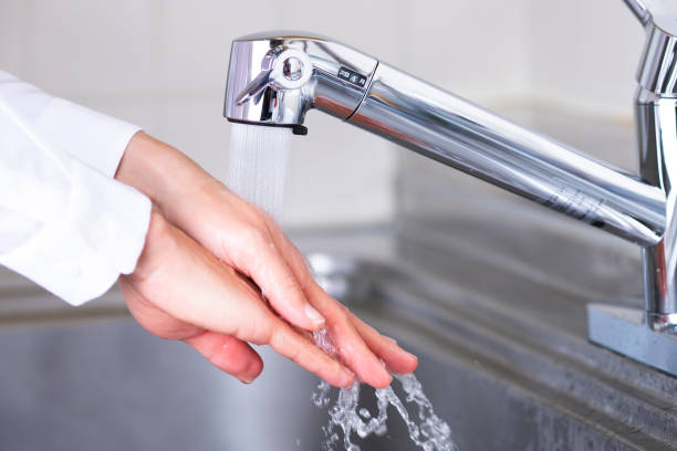 istock Woman washing hands in kitchen 1363176471