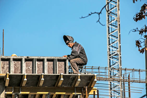 Dnepropetrovsk, Ukraine - 10.20.2021: A welder prepares a frame from reinforcement for pouring concrete into the load-bearing girder of a residential building.