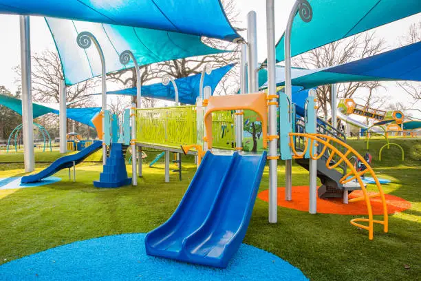 Photo of Modern playgound with slides, bridge, climbing stairs, and canopy