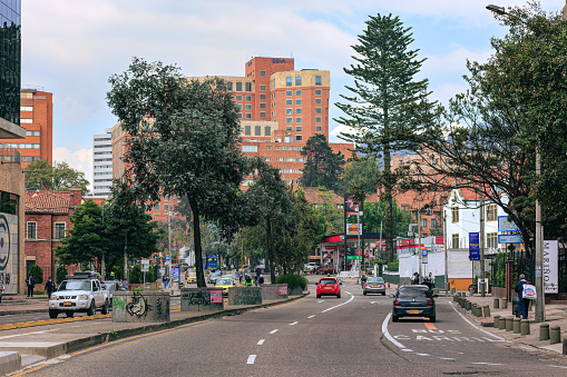 Bogotá, Colombia - November 13, 2021: The drivers point of view on the Northbound carriageway of Carrera Septima driving through the Chapinero area in the Andean capital city of Bogota, in South America. To the left are the Southbound carriageways. There are office and residential apartment buildings on both sides of the major arterial road. The Bicycle Lane can be seen to the left and the clearly marked Bus Lane to the right. The altitude at street level is 8,660 feet above mean sea level. Horizontal format. Copy space.