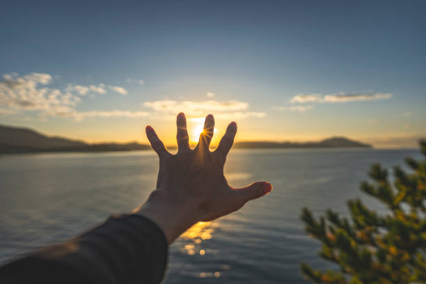 istock A man's hand holding his hand over the morning sun 1363190894