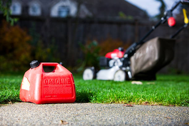 Gasoline container with a mower on the background stock photo