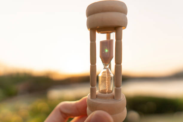 istock Hourglass with hand and sea view 1363194119