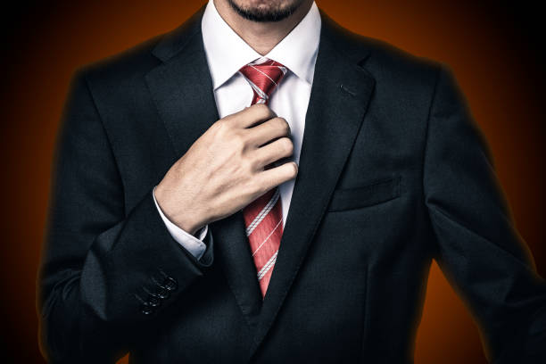 istock Businessman with red tie on dark background 1363195862