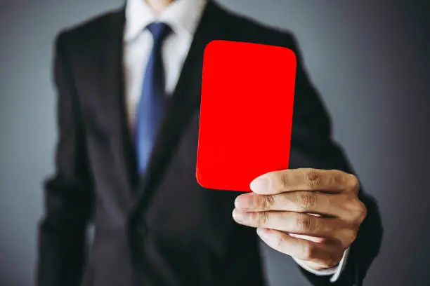 Photo of Businessman holding a red card