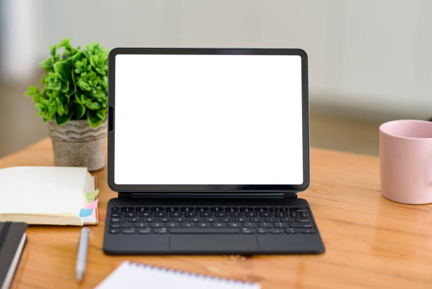 istock Digital tablet blank white screen with keyboard on wooden table. Mock up. 1363196950
