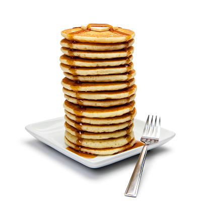 This is a photograph of a large tall stack of pancakes on a white background