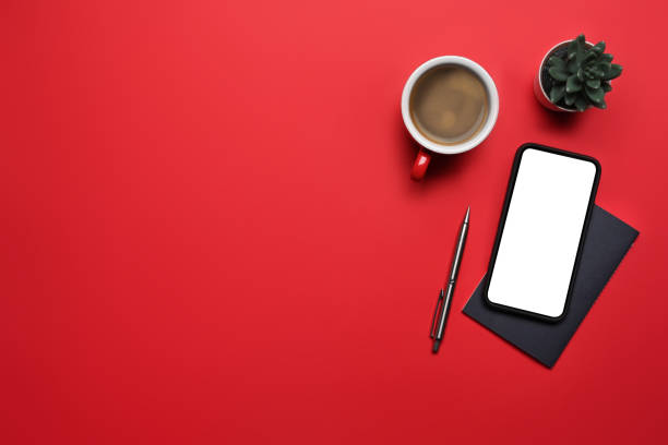 istock Mock up smart phone, coffee cup and notebook on red background with copy space for text. 1363199979