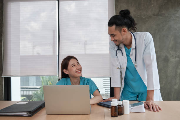 Two uniformed young doctors work in medical clinic office.