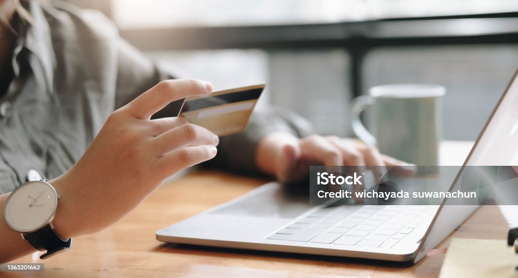 Online payment,woman's hands holding a credit card and using laptop computer for online shopping with vintage filter tone Credit Card Stock Photo