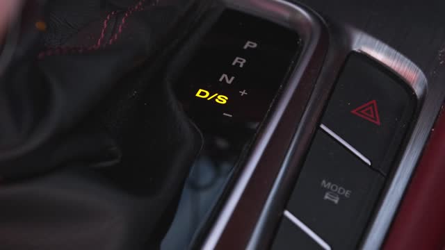 Close-up of a driver holding an automatic gear lever to change gears in a car. Automatic transmission, automatic gear shift, is moved from P Park to D Drive.