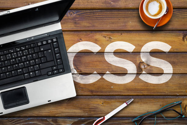 Word CSS on wooden desk and laptop Cascading Style Sheets. cascading style sheets stock pictures, royalty-free photos & images