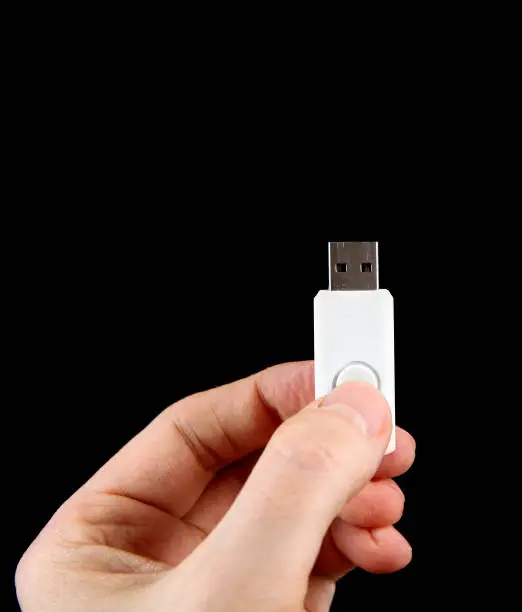 USB Drive in the Hand on the Black Background