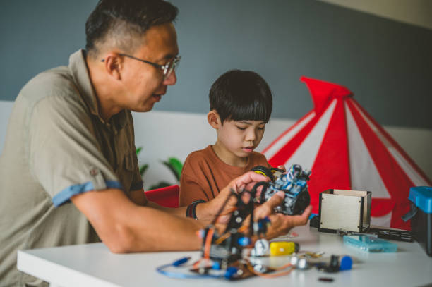 istock Optimistic Asian father and son enjoying their robotic hobby 1363207596