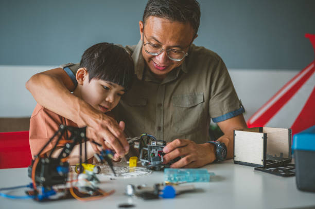 istock Optimistic Asian father and son enjoying their robotic hobby 1363207599