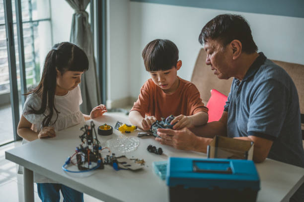 istock Optimistic Asian grand father and his grandchild enjoying their robotic hobby 1363207607