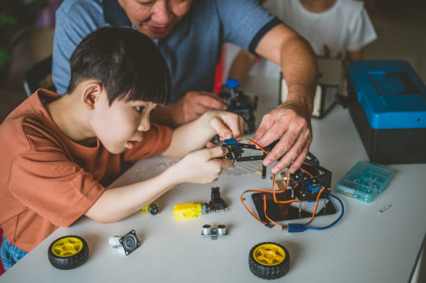 istock Optimistic Asian grand father and grandson enjoying their robotic hobby 1363207618