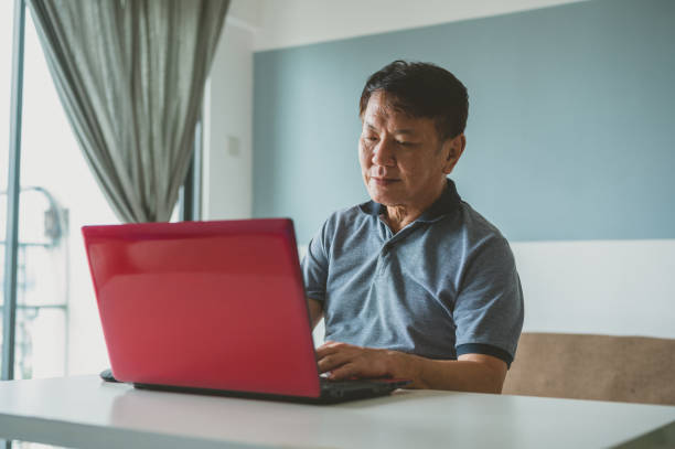 istock Senior Asian man is working from home 1363207655
