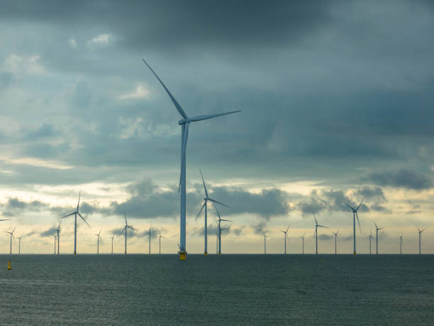 vue aérienne, d’énormes moulins à vent se dressent dans la mer le long d’une mer hollandaise. - horizon over water white green blue photos et images de collection