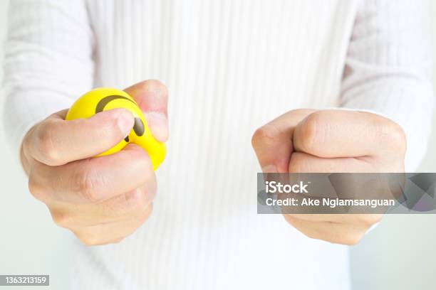Hands Of A Young Man With A Gentle Personality He Exhibits Stressful Behavior From Work And He Squeezes The Yellow Ball Expressing Emotion Anger Displeasure Medical Concepts And Emotional Regulation Stock Photo - Download Image Now
