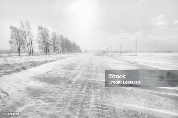 Icy Winter Road A Blizzard Is Sweeping The Road Stock Photo - Download Image Now - Blizzard, Snow, Road