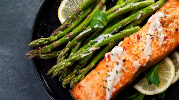 istock Baked salmon with asparagus on gray background. 1363216361