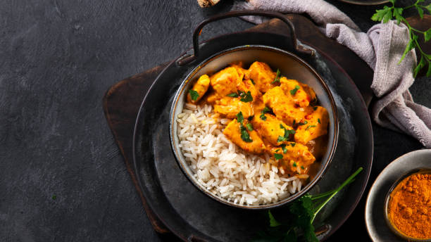 istock Indian butter chicken curry with basmati rice on dark background. 1363217465